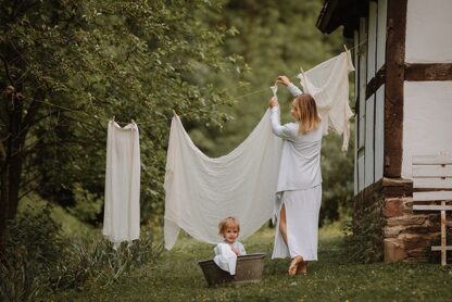 mama mit kind hängt wäsche auf