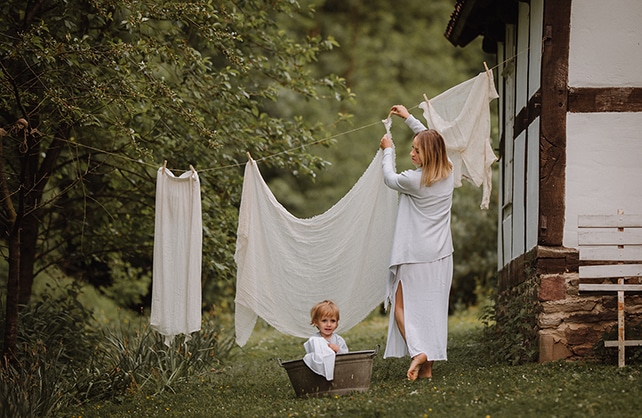 mama mit kind hängt wäsche auf