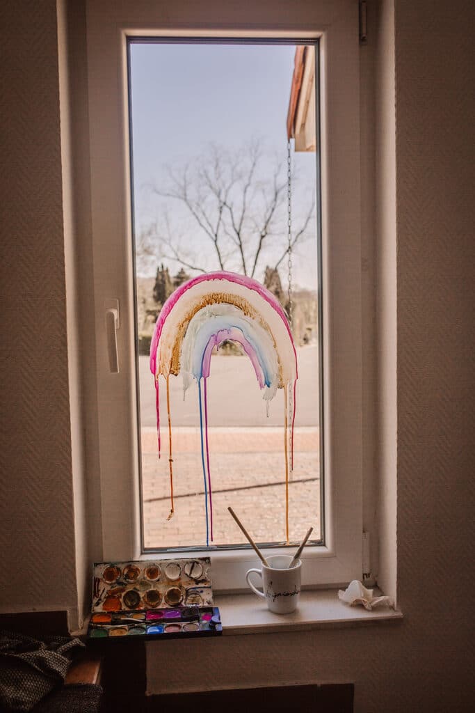 regenbogen gegen corona. kinder malen regenbogen an die Fenster